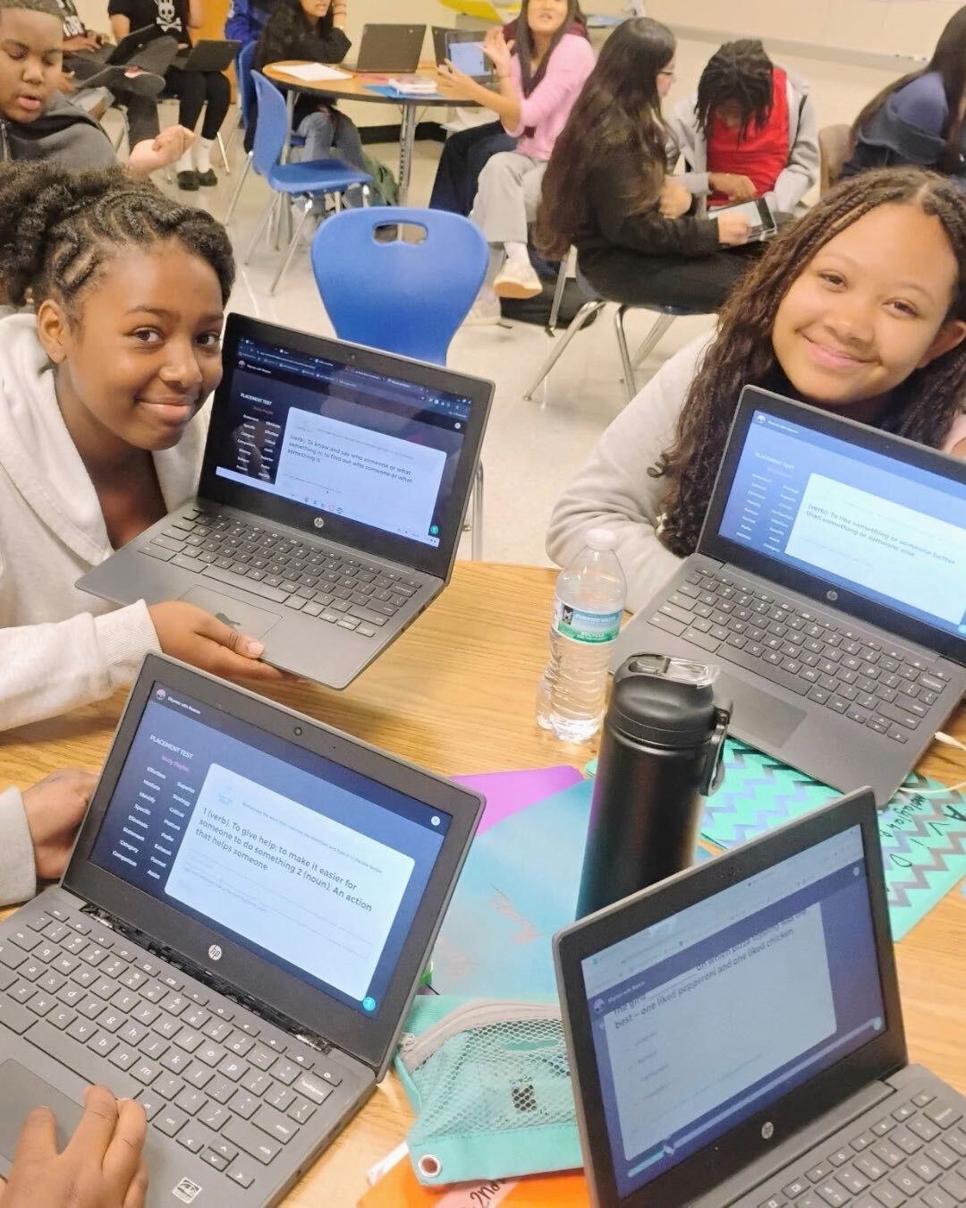 Students sharing their Rhymes with Reason vocabulary work on laptops.